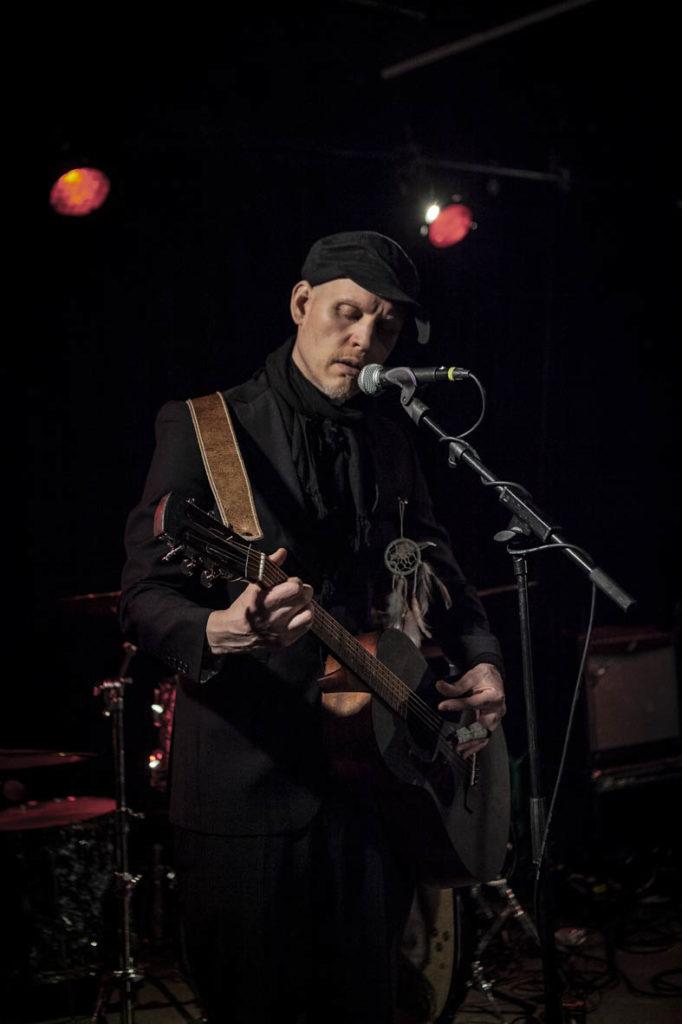 Kuvassa artisti SPK Toivonen lavalla, soittamassa kitaraa ja laulamassa